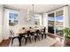 Elegant dining room with a modern light fixture, a large table with seating for eight, and sliding glass doors at 3081 Youngheart Way, Castle Rock, CO 80109