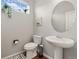 Clean powder room featuring a pedestal sink, decorative mirror, and a window bringing in natural light at 3081 Youngheart Way, Castle Rock, CO 80109