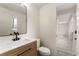 This bathroom features a modern vanity, black hardware, white walls and floors, and an open doorway at 6448 Ingalls Ct, Arvada, CO 80003