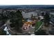 Aerial view of a luxurious estate with a fire pit, meticulously manicured lawns, and mature trees at 7225 Box Canyon Rd, Sedalia, CO 80135