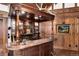 Custom bar area with wood trim, glassware storage, sink, and room to entertain at 7225 Box Canyon Rd, Sedalia, CO 80135