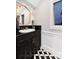 Stylish bathroom with a dark vanity, marble sink, and black-and-white patterned tile flooring at 7225 Box Canyon Rd, Sedalia, CO 80135