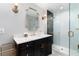 Stylish bathroom featuring a black vanity, modern fixtures, and a glass-enclosed shower at 7225 Box Canyon Rd, Sedalia, CO 80135