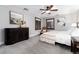 Neutral bedroom with a ceiling fan, simple furnishings, and natural light from two windows at 7225 Box Canyon Rd, Sedalia, CO 80135