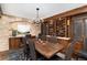 Charming dining room featuring a stone accent wall, wine rack, and elegant dark wood table and chairs at 7225 Box Canyon Rd, Sedalia, CO 80135