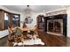 Inviting dining room features a round table, brick fireplace, hardwood floors and unique light fixture at 7225 Box Canyon Rd, Sedalia, CO 80135