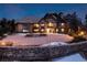 Stunning Tudor-style home with a circular driveway and beautiful stone accents at twilight at 7225 Box Canyon Rd, Sedalia, CO 80135