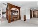 Elegant hallway featuring detailed wood trim, patterned carpet, and a stunning chandelier at 7225 Box Canyon Rd, Sedalia, CO 80135