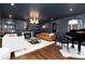 Chic living room with dark walls, a fireplace, and a piano for a cozy yet sophisticated ambiance at 7225 Box Canyon Rd, Sedalia, CO 80135