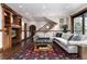 Elegant living room featuring a stylish rug, comfortable gray sectional sofa, and custom built-ins at 7225 Box Canyon Rd, Sedalia, CO 80135