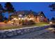 Expansive backyard featuring a glass conservatory, lush landscaping, and a stone retaining wall at 7225 Box Canyon Rd, Sedalia, CO 80135