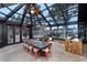 Glass enclosed sun room with exposed beams, large dining table, and beautiful views at 7225 Box Canyon Rd, Sedalia, CO 80135