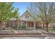 Charming brick home featuring a wrought iron fence and a mature shade tree in the front yard at 3356 Quivas St, Denver, CO 80211