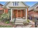 Inviting front porch of a brick home with classic columns and a wooden front door at 3356 Quivas St, Denver, CO 80211