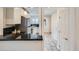 Bright kitchen features white cabinetry, stainless steel appliances, and black countertops at 3356 Quivas St, Denver, CO 80211