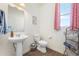 Well-lit half bathroom with modern fixtures and a stylish pedestal sink at 24222 E Canyon Pl, Aurora, CO 80016