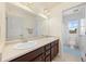 Well-lit bathroom featuring double sinks and a vanity with private toilet room at 24222 E Canyon Pl, Aurora, CO 80016