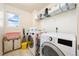 Functional laundry room equipped with a modern washer and dryer and shelving for storage at 24222 E Canyon Pl, Aurora, CO 80016