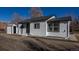 Exterior shot of the house featuring white exterior with black trim and a gray roof at 1435 Jay St, Lakewood, CO 80214