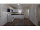 Bright kitchen with white cabinets, appliances, and wood floors with an open layout at 1435 Jay St, Lakewood, CO 80214