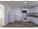 Bright kitchen with white appliances, stylish cabinets, and wood-look flooring at 1435 Jay St, Lakewood, CO 80214