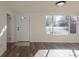 Bright living room with wood floors, large windows, and a white front door with a decorative window at 1435 Jay St, Lakewood, CO 80214