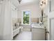 Charming bathroom features a clawfoot tub, white tile floor, and marble top vanity at 685 N Emerson St, Denver, CO 80218