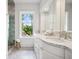 Bright bathroom featuring marble counters, tiled floor, shower, and an exterior window at 685 N Emerson St, Denver, CO 80218