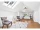 Sun-filled bedroom with hardwood floors, neutral decor, a skylight and stylish sitting area at 685 N Emerson St, Denver, CO 80218
