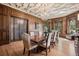 Dining room featuring wood paneling, an ornate ceiling, a chandelier, and access to another room through glass doors at 685 N Emerson St, Denver, CO 80218