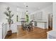 Spacious kitchen featuring white cabinetry, stainless steel appliances, hardwood floors, and a glass dining table at 685 N Emerson St, Denver, CO 80218