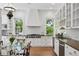 Bright kitchen with white cabinets, stainless steel appliances, a glass dining table, and hardwood floors at 685 N Emerson St, Denver, CO 80218