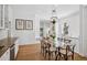 Open kitchen and dining area featuring white cabinets, hardwood floors, wainscoting, and stylish pendant lighting at 685 N Emerson St, Denver, CO 80218