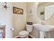 Half bathroom featuring a pedestal sink, hardwood floors, and decorative artwork at 4061 Nordland Trl, Castle Rock, CO 80109