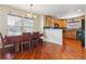 Dining room featuring beautiful hardwood floors, a large window with natural light, and an adjacent kitchen area at 4061 Nordland Trl, Castle Rock, CO 80109