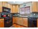 Well-equipped kitchen featuring black appliances, a gas stove, and natural wood cabinets at 4061 Nordland Trl, Castle Rock, CO 80109