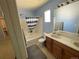 Bathroom featuring double sink vanity, bathtub with shower, and blue walls at 21300 E 42Nd Ave, Denver, CO 80249