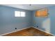 Bedroom with wood floor and light blue walls, window boarded up at 415 Winona Ct, Denver, CO 80204