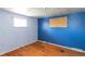 Bedroom with hardwood floors and blue walls, window boarded up at 415 Winona Ct, Denver, CO 80204