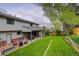 Spacious backyard with patio, manicured lawn, mature trees, and outdoor seating at 66 Yank Way, Lakewood, CO 80228