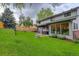 Lush backyard with patio area, well-maintained lawn, mature trees, and privacy fence at 66 Yank Way, Lakewood, CO 80228