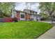 Beautifully landscaped front yard with lush green grass and mature trees at 66 Yank Way, Lakewood, CO 80228