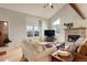 Cozy living room with hardwood floors, a brick fireplace, vaulted ceilings, and large windows at 66 Yank Way, Lakewood, CO 80228