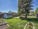 Spacious backyard with mature trees, lush green lawn, and garden shed at 5225 Beech St, Arvada, CO 80002