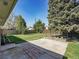 Well-maintained backyard featuring a concrete patio, garden beds, and lush green lawn at 5225 Beech St, Arvada, CO 80002