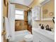 Bathroom featuring a shower-tub combo with decorative tile surround and vanity with storage at 5225 Beech St, Arvada, CO 80002