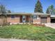 Charming brick home featuring a well-manicured lawn and cozy front porch at 5225 Beech St, Arvada, CO 80002