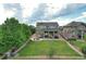 Aerial view of a backyard with a large lawn, stone patio with fire pit and two-story home at 7892 S Country Club Pkwy, Aurora, CO 80016