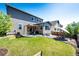 Wide backyard with a patio, seating area, fire pit, and lush green lawn at 3966 Long Rifle Dr, Castle Rock, CO 80108