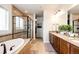 Beautiful bathroom featuring double vanity, a large soaking tub, and a separate glass shower at 3966 Long Rifle Dr, Castle Rock, CO 80108